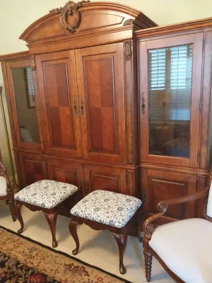 Sale Photo Thumbnail #51: Large traditional cherry-finished entertainment armoire with flanking glass-door cabinets, paired with two upholstered cabriole-leg footstools.