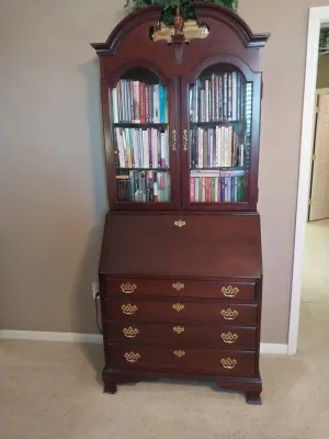 Sale Photo Thumbnail #75: Traditional mahogany slant-top secretary desk with a broken-arch pediment, glass-front upper bookcase, and brass batwing hardware.