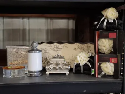 Collection of decorative home accents, including a mercury glass vase, milk glass jar with shell finial, silver-tone trinket box, and...