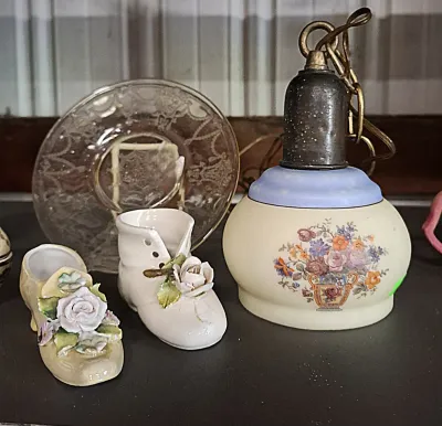 Vintage ceramic pendant light shade with floral design, paired with miniature porcelain shoe figurines and a clear glass saucer.