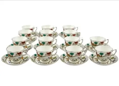 Sale Photo Thumbnail #110: Vintage ceramic teacup and saucer set featuring a rustic cottage and landscape pattern with green trees and red-roofed houses.