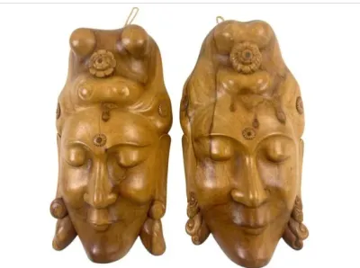 Sale Photo Thumbnail #100: Pair of vintage carved wooden Buddha head wall masks, featuring detailed headdresses and serene expressions.