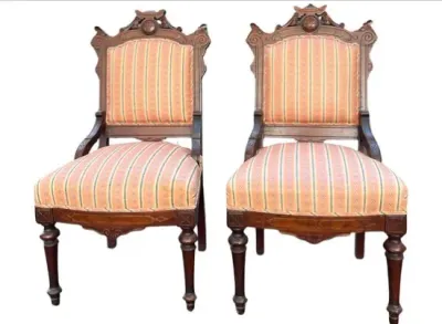 Sale Photo Thumbnail #20: Pair of Victorian carved walnut side chairs featuring ornate cresting, turned legs, and striped fabric upholstery.