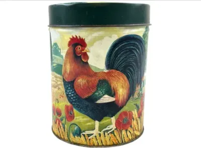 Sale Photo Thumbnail #102: Vintage metal canister featuring a colorful rooster illustration in a countryside setting with poppies and wheat, complete with a dark green lid.