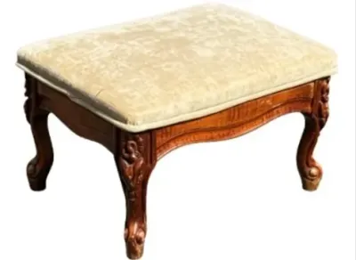 Sale Photo Thumbnail #191: Vintage French Provincial style footstool featuring a carved wooden frame with cabriole legs and a cream-colored crushed velvet upholstered seat.