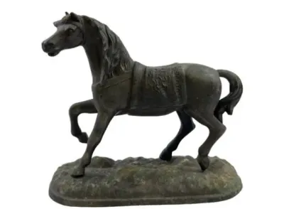 Sale Photo Thumbnail #87: Cast metal or bronze horse figurine mounted on an integral base, featuring detailed saddle and mane accents with an aged patina.
