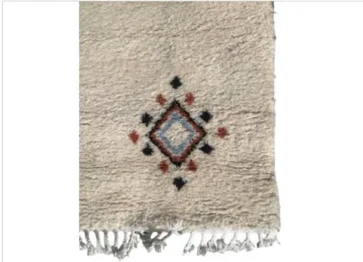 Sale Photo Thumbnail #55: Off-white wool area rug featuring a subtle geometric diamond motif in blue, rust, and black with fringed edges.
