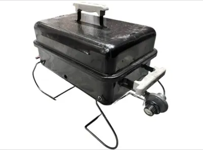 Sale Photo Thumbnail #33: Portable Weber Go-Anywhere gas grill featuring a black porcelain-enameled body, folding wire legs, and heat-resistant handles.