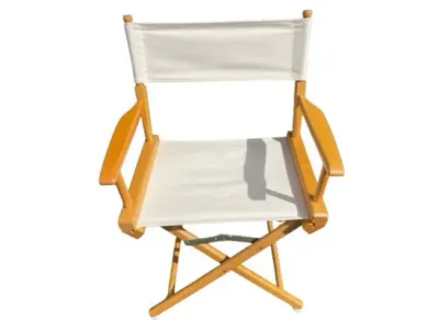 Sale Photo Thumbnail #25: Classic folding director's chair featuring a natural wood frame and white canvas seat and backrest.