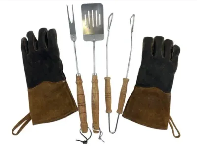 Sale Photo Thumbnail #119: Vintage barbecue tool set including wooden-handled spatula, fork, and tongs, accompanied by a pair of heavy-duty suede grilling gloves.