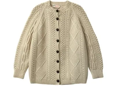 Sale Photo Thumbnail #143: Cream-colored chunky cable-knit wool cardigan featuring a button-down front with dark round buttons, raglan sleeves, and textured honeycomb patterns.