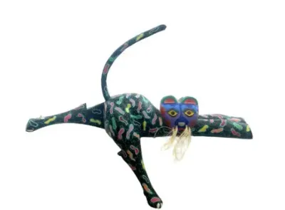 Sale Photo Thumbnail #155: Hand-painted Oaxacan wood carving of a leaping jaguar or cat featuring vibrant multicolored patterns on a dark ground with straw whiskers.