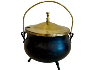 Sale Photo Thumbnail #84: Vintage miniature cauldron-style metal pot with a fitted brass lid, bail handle, and three small feet.