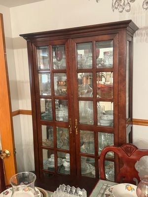 Sale Photo Thumbnail #10: Traditional cherry wood display hutch with glass paned doors, housing various glassware and china.