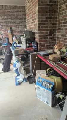 Collection of household and garage items, including a blue and white vacuum cleaner, folding tables, hand tools, birdhouses, and various...