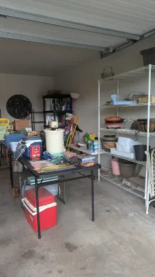 Sale Photo Thumbnail #30: Garage storage scene with various household items, including a vintage white electric ice cream maker, red and blue plastic coolers, garden pots, and wire shelving units.