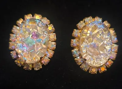 Sale Photo Thumbnail #44: Vintage mid-century aurora borealis mosaic clip-on earrings featuring iridescent crushed glass center stones framed by prong-set rhinestone halos.
