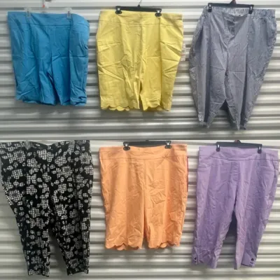Sale Photo Thumbnail #53: Collection of women's plus-size shorts and cropped pants in various solid colors and patterns, displayed hanging on a slatwall.