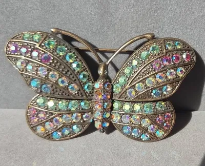Sale Photo Thumbnail #46: Vintage bronze-tone butterfly brooch heavily encrusted with iridescent aurora borealis rhinestones.