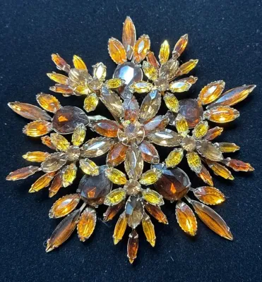 Sale Photo Thumbnail #74: Vintage layered starburst brooch set with amber, topaz, and smoky yellow rhinestone crystals.
