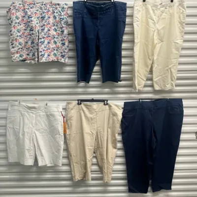 Sale Photo Thumbnail #49: Collection of women's plus-size shorts and pants hung on a wall display, including floral, denim, beige, white, and navy styles.