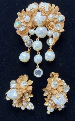 Sale Photo Thumbnail #96: Vintage gold-tone floral jewelry set featuring a dangling brooch pin and matching clip-on earrings accented with faux pearls and rhinestones.