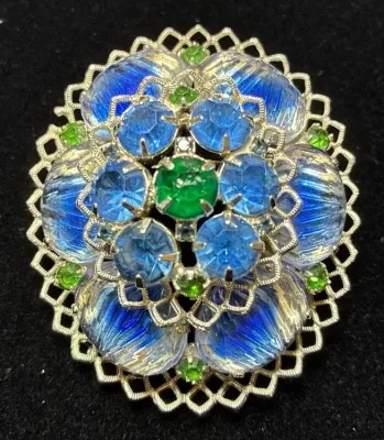 Sale Photo Thumbnail #103: Vintage gold-tone filigree brooch featuring blue and green rhinestones and iridescent glass cabochons.