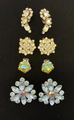 Sale Photo Thumbnail #82: Collection of four pairs of mid-century clip-on earrings featuring clear rhinestone and iridescent aurora borealis glass designs.