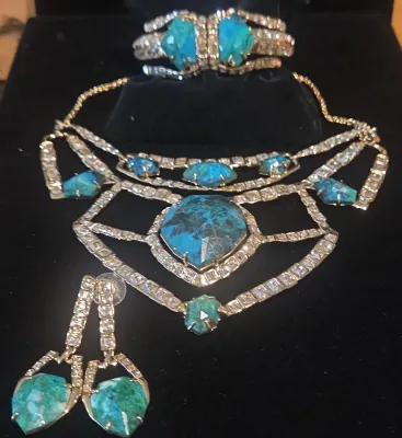 Sale Photo Thumbnail #30: Vintage gold-tone rhinestone and turquoise-colored stone jewelry set, including a statement bib necklace, matching drop earrings, and a hinged cuff bracelet.