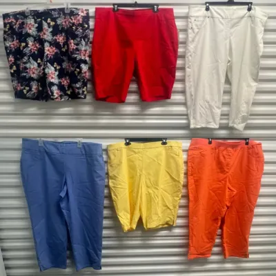 Sale Photo Thumbnail #52: Collection of women's colorful shorts and capri pants, including floral patterned, bright red, white, periwinkle blue, yellow, and coral orange pairs hung on a wall display.