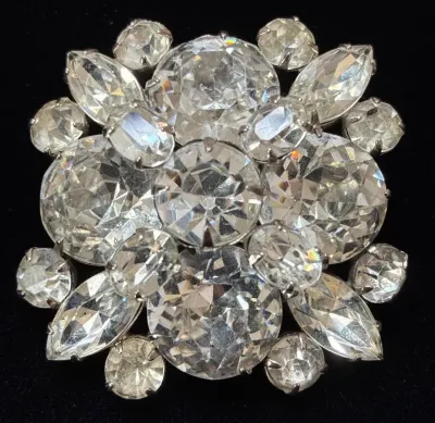 Sale Photo Thumbnail #59: Vintage silver-tone rhinestone starburst brooch featuring layered round, marquise, and oval prong-set glass stones.