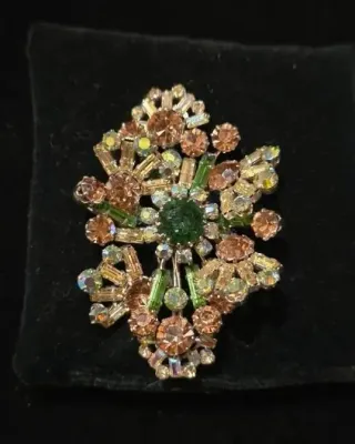 Sale Photo Thumbnail #121: Vintage cluster brooch featuring round, baguette, and aurora borealis rhinestones in shades of amber, green, and iridescent crystal.