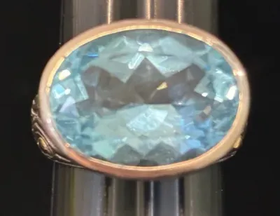Sale Photo Thumbnail #7: Large oval faceted light blue topaz or aquamarine ring set in a thick bezel setting with ornate shoulders.