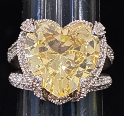 Sale Photo Thumbnail #86: Heart-shaped yellow cubic zirconia or stone ring featuring a halo setting and a split-shank band encrusted with clear accent stones.