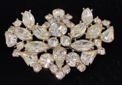 Sale Photo Thumbnail #106: Vintage silver-tone rhinestone brooch featuring an intricate spray design with marquise, teardrop, and round cut crystal stones.