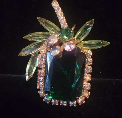 Sale Photo Thumbnail #27: Vintage pineapple-shaped rhinestone brooch featuring a large emerald green glass center stone framed by iridescent rhinestones and olive green marquise-cut leaves.