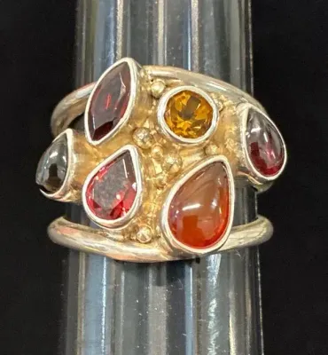 Sale Photo Thumbnail #111: Sterling silver multi-gemstone statement ring featuring garnet, citrine, and carnelian stones on a ring sizer.