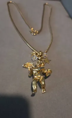 Sale Photo Thumbnail #33: Gold-tone chain necklace featuring a cherub or angel pendant with star charms and crystal accents.
