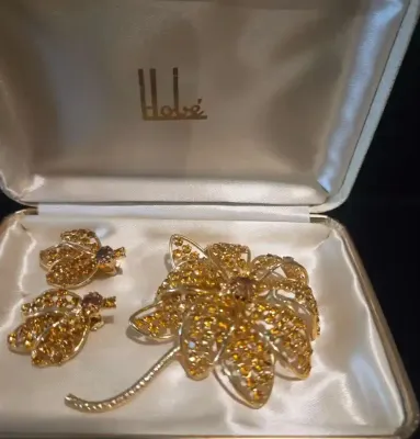 Sale Photo Thumbnail #69: Vintage Hobé floral brooch and matching clip-on earrings set with topaz-colored rhinestones, presented in original satin-lined box.
