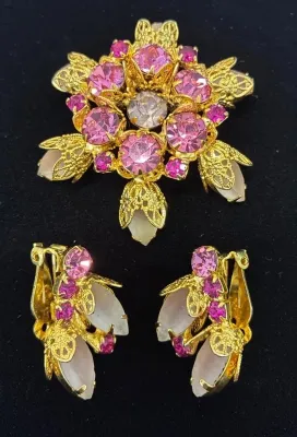 Sale Photo Thumbnail #83: Vintage gold-tone floral brooch and matching clip-on earrings set with pink rhinestones and white cabochons.
