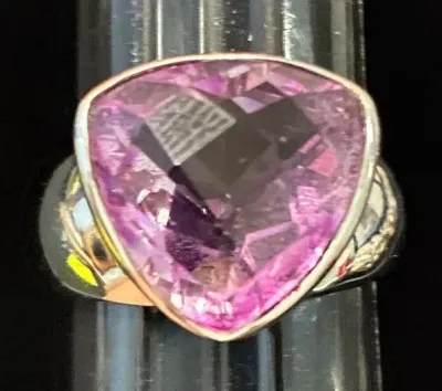 Sale Photo Thumbnail #2: Statement ring featuring a large, trillion-cut pink gemstone bezel-set in silver-tone metal.