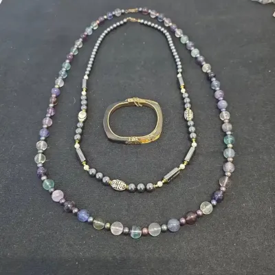 Sale Photo Thumbnail #62: Set of three jewelry pieces including a fluorite beaded strand, a hematite necklace with Chinese shou character beads, and a gold-tone and horn-style hinged bangle.