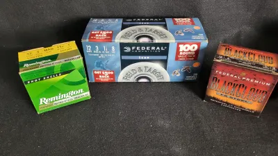 Three boxes of 12-gauge shotgun ammunition, including Federal Ammunition Field & Target 100-round value pack, Remington Premier...