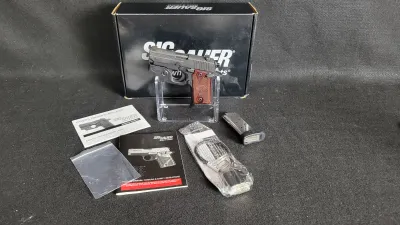 Sig Sauer P238 semi-automatic pistol with rosewood grips, mounted trigger guard laser, spare magazine, owner's manuals, and original...