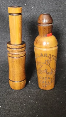 Pair of vintage wooden game calls, including a Mallardtone duck call with carved flying duck graphics.