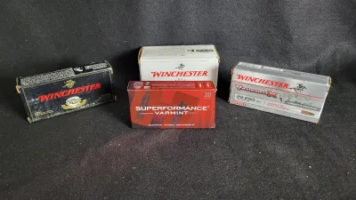 Collection of four boxes of rifle ammunition, including Winchester and Hornady Superformance Varmint, shown in original packaging.