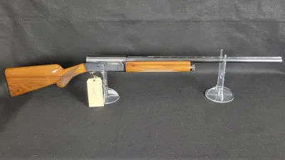 Browning Auto-5 semi-automatic shotgun with polished wood stock and forearm, featured on clear acrylic display stands.