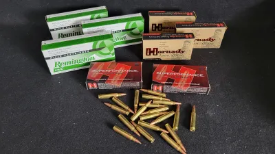 Selection of boxed rifle ammunition including Remington UMC and Hornady Superformance Varmint, along with a pile of loose centerfire...
