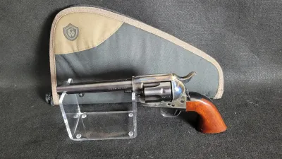 Single-action revolver chambered in .357 Magnum featuring wooden grips and a case-hardened finish, displayed on a clear stand with an...