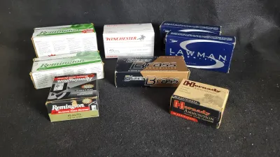 Assortment of boxed pistol ammunition, including Remington, Winchester, Speer Lawman, Blazer Brass, and Hornady brands.